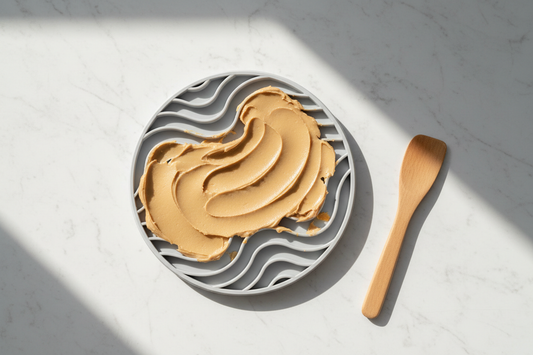 Silicone lick mat with textured grooves spread with soft food on a clean stone surface — a guide to what lick mats actually do, by LAVORA