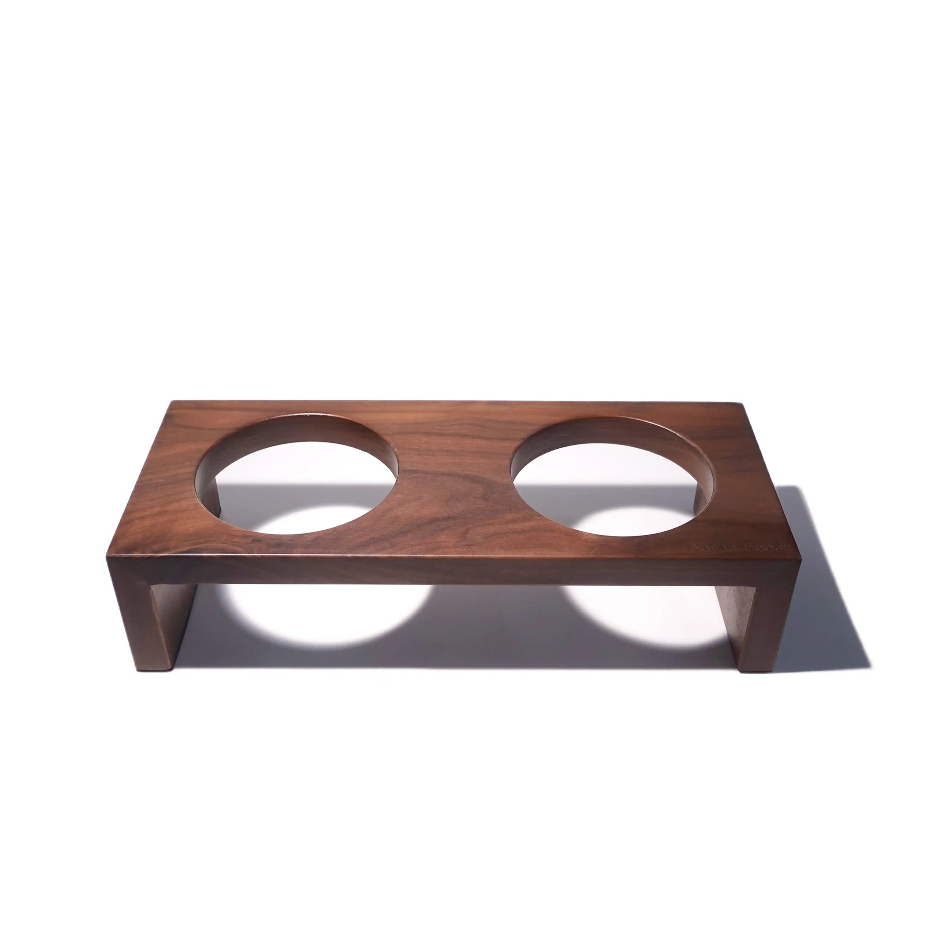 Wooden pet feeder with two circular cutouts on a white background