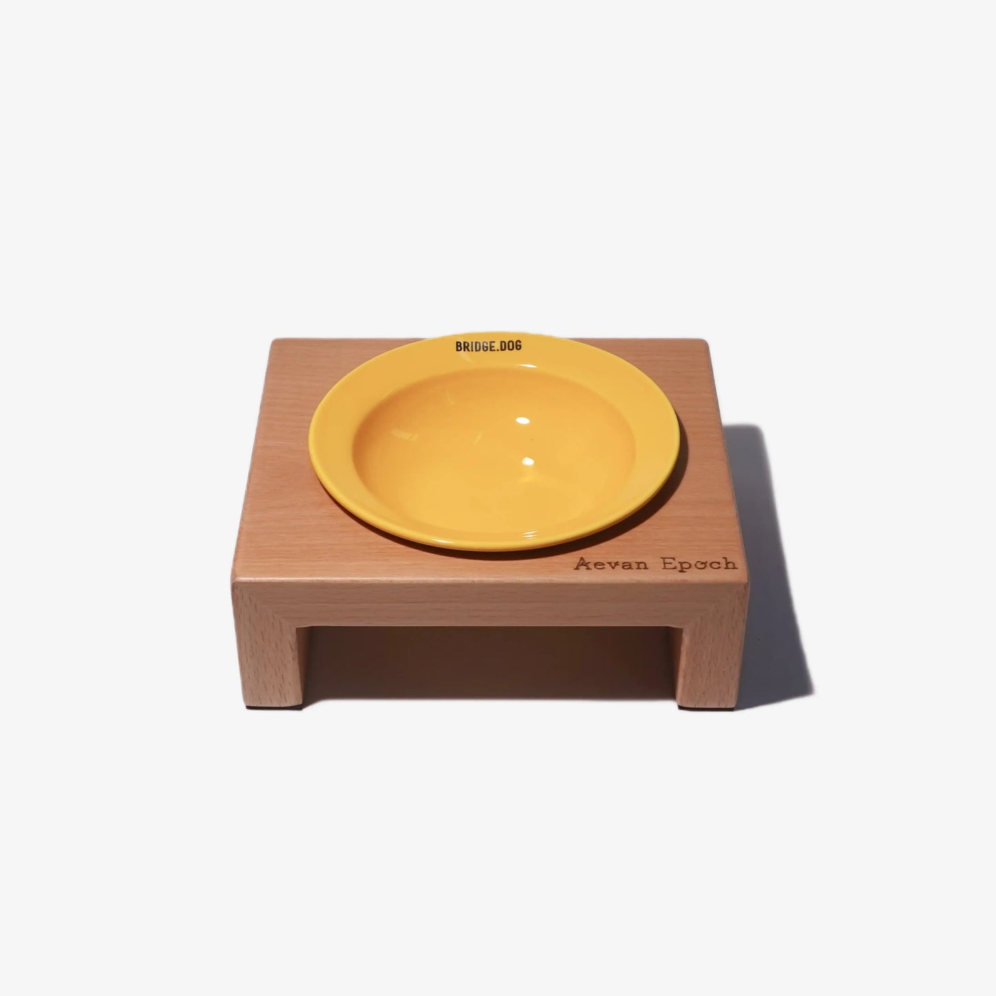 Yellow bowl on a wooden stand with 'Aeven Epoch' branding on a white background